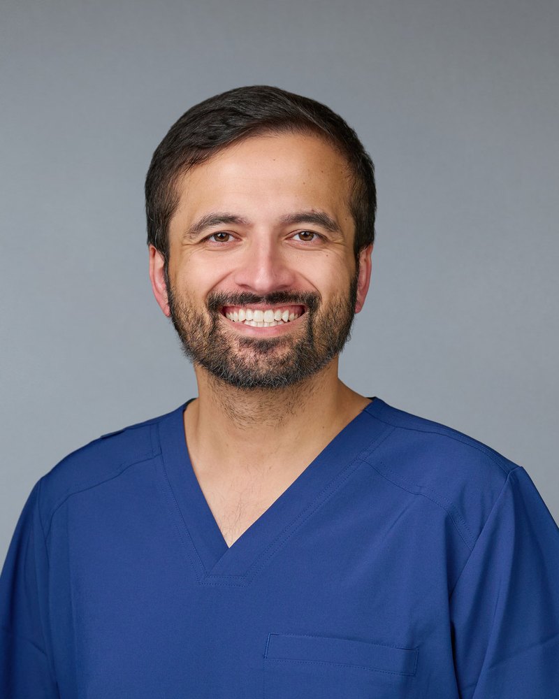 Dr. Farhan Abdullah, DO, board certified in Internal Medicine, in navy scrubs