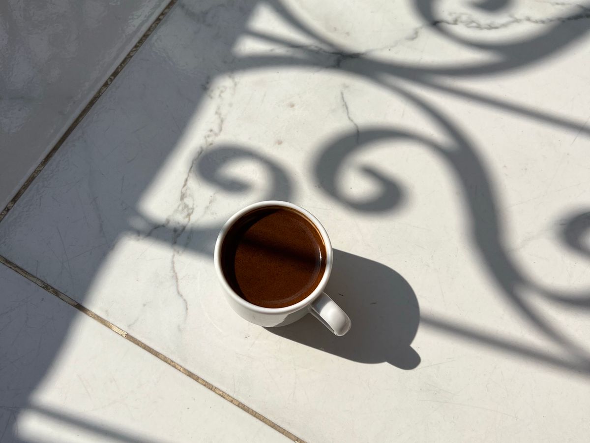 A cup of coffee on a sunlit table