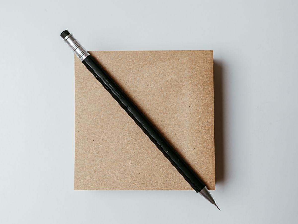 A pencil resting on a closed notebook